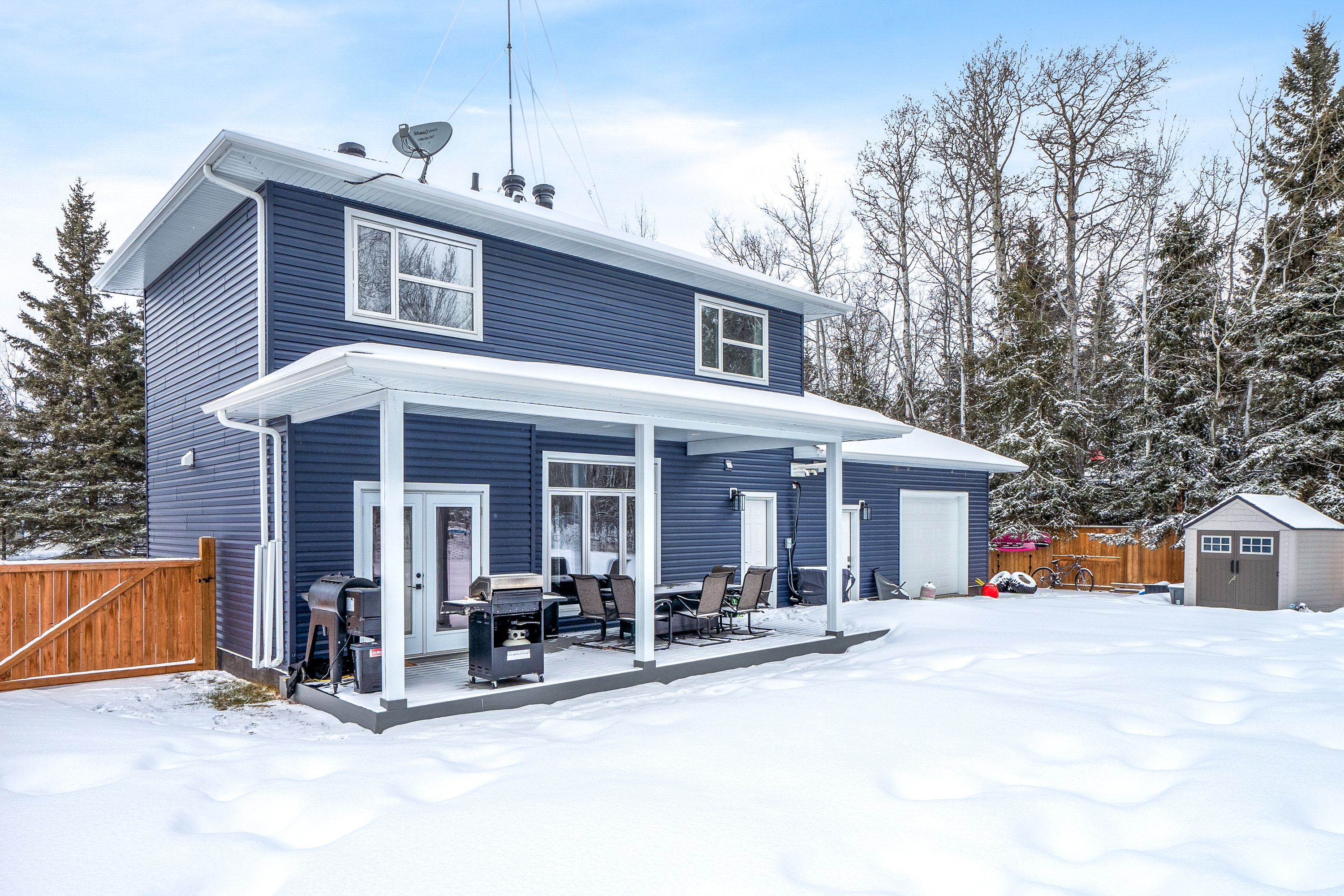 Lake house rear exterior with covered patio in winter