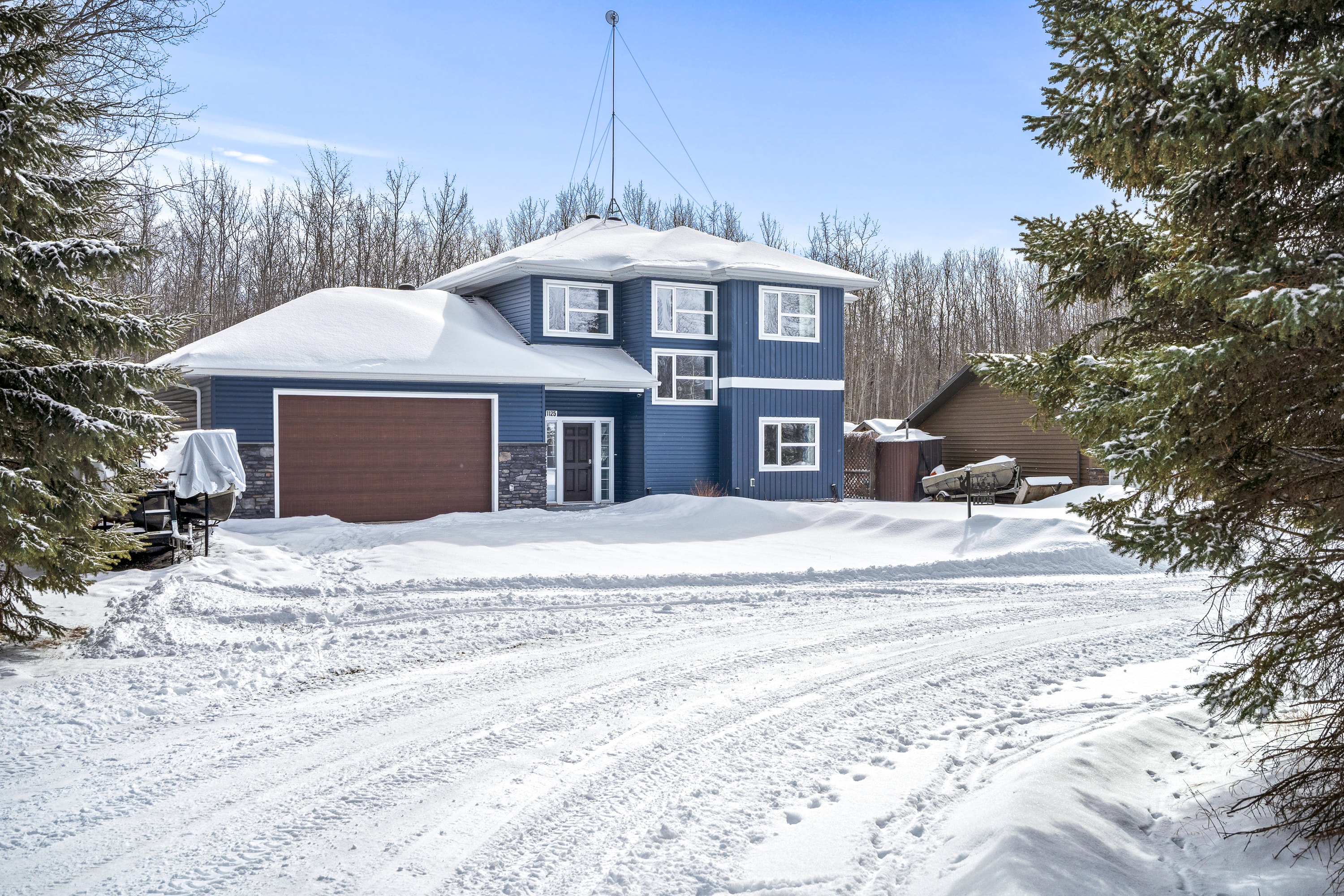 Blue Lake House exterior with garage door in winter
