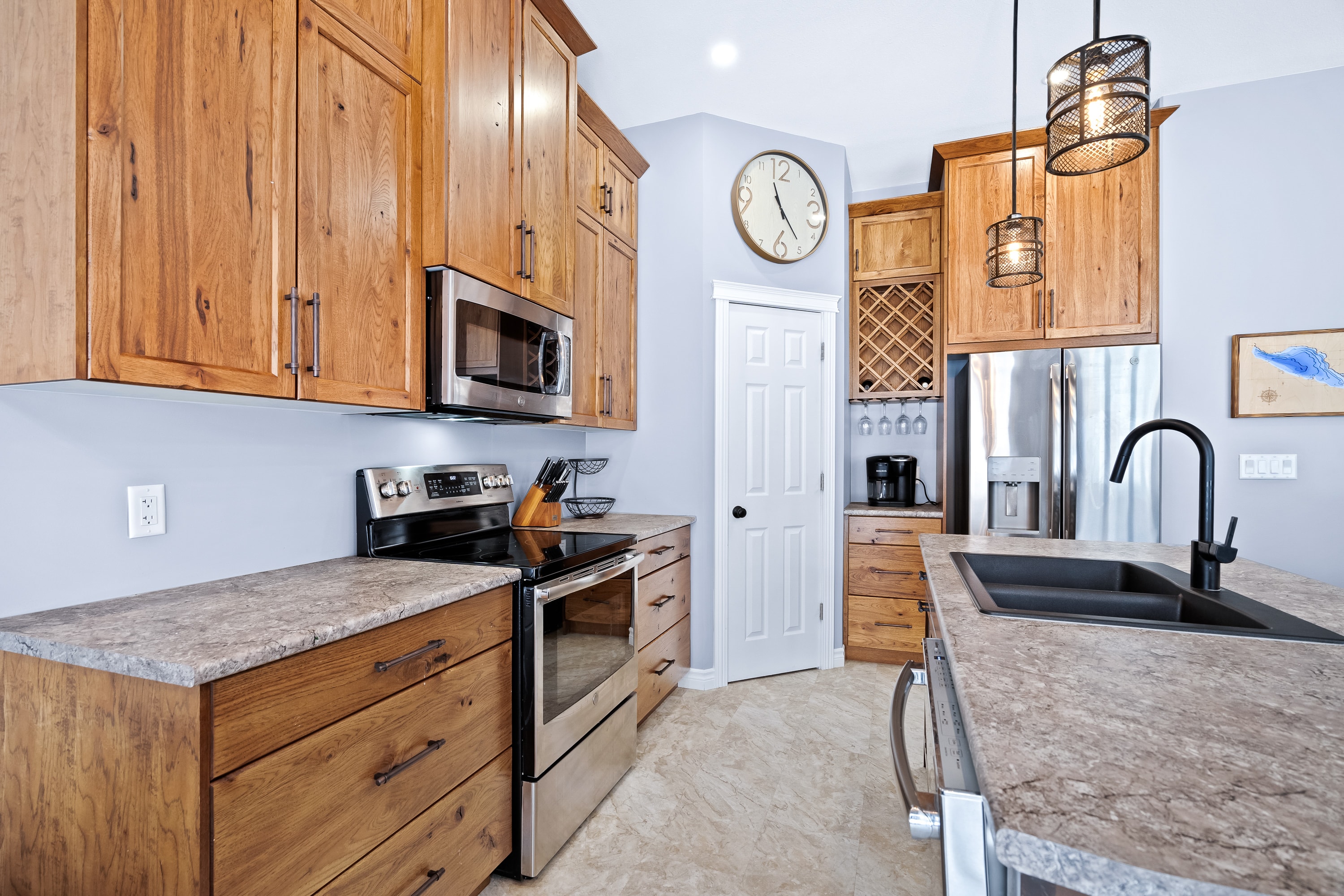 Lake house kitchen with custom wood cabinetry, stone countertops, and island