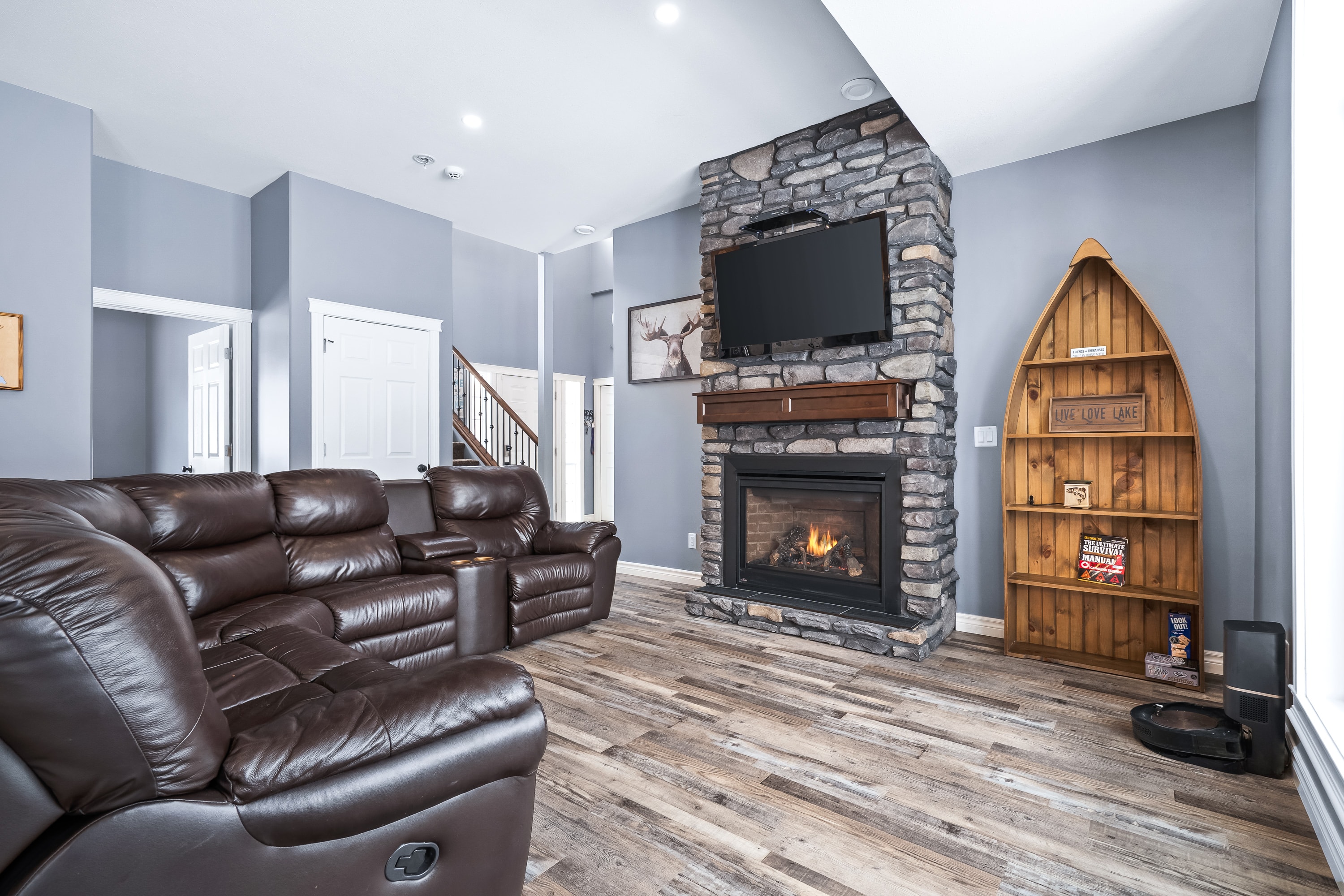 Lake house living room with stone fireplace and leather seating