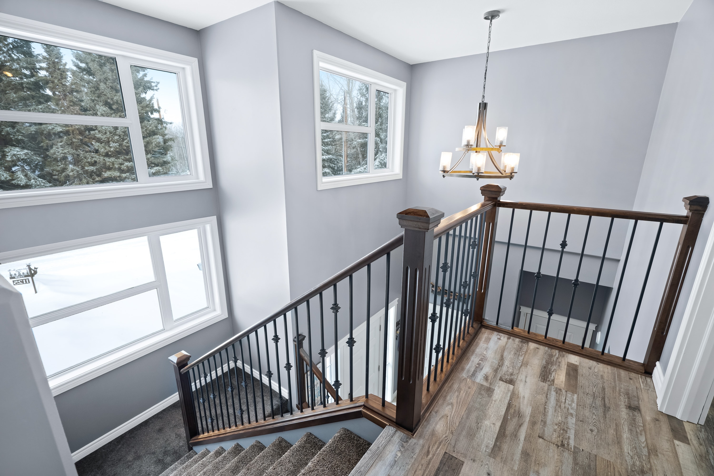 Lake house upper staircase landing with chandelier