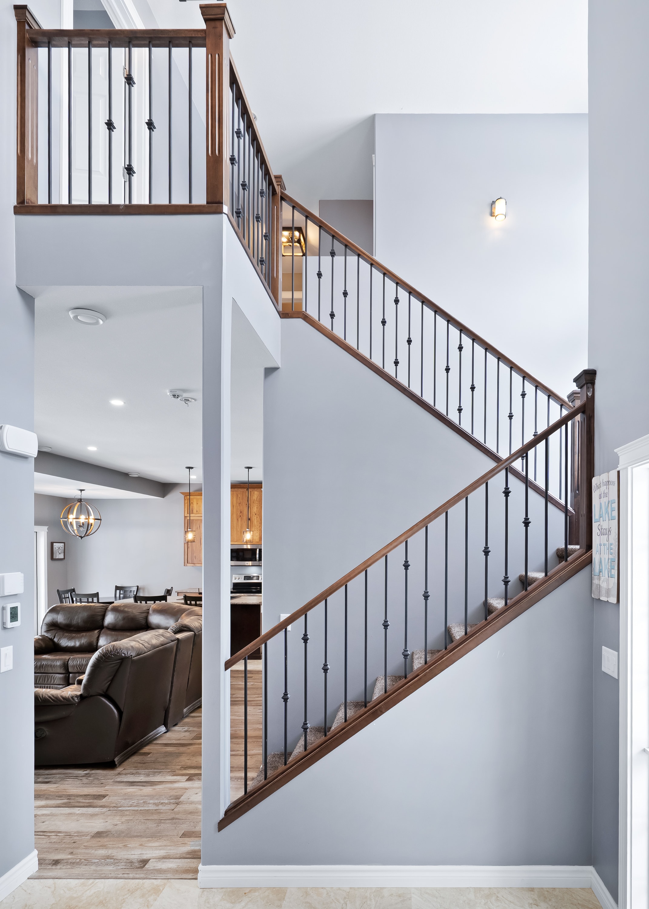 Lake house staircase with dark wood railings and black metal balusters